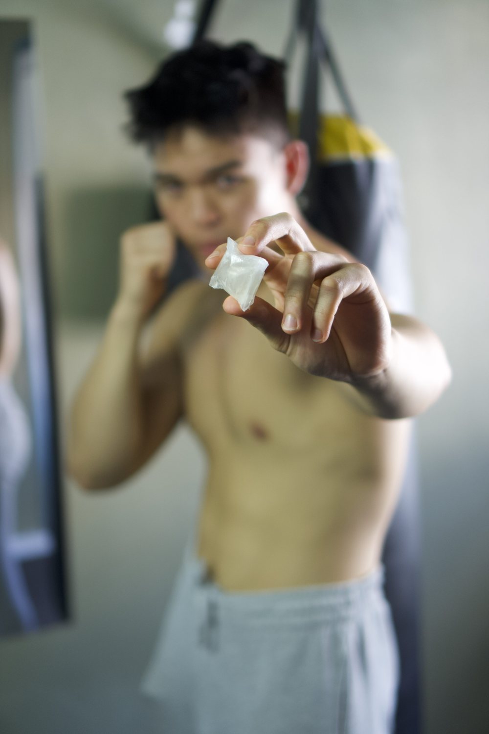 Boxer holding a sachet beside the heavy bag